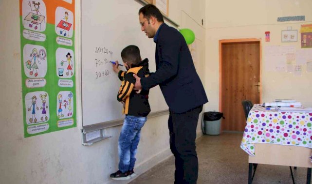 Elazığ'daki fedakar öğretmen engelli öğrencisine yardım ediyor