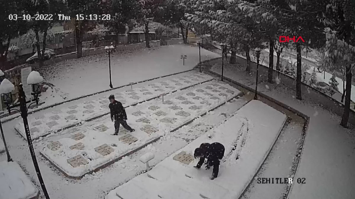 Çanakkale'de 2 genç, beyaza bürünen şehitlikteki mezar taşlarını temizledi