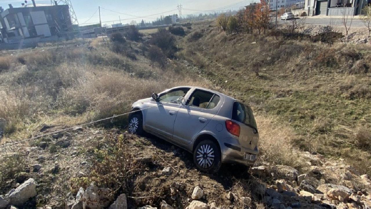 Çorum'da yoldan çıkan otomobil, taşlık alanda asılı kaldı