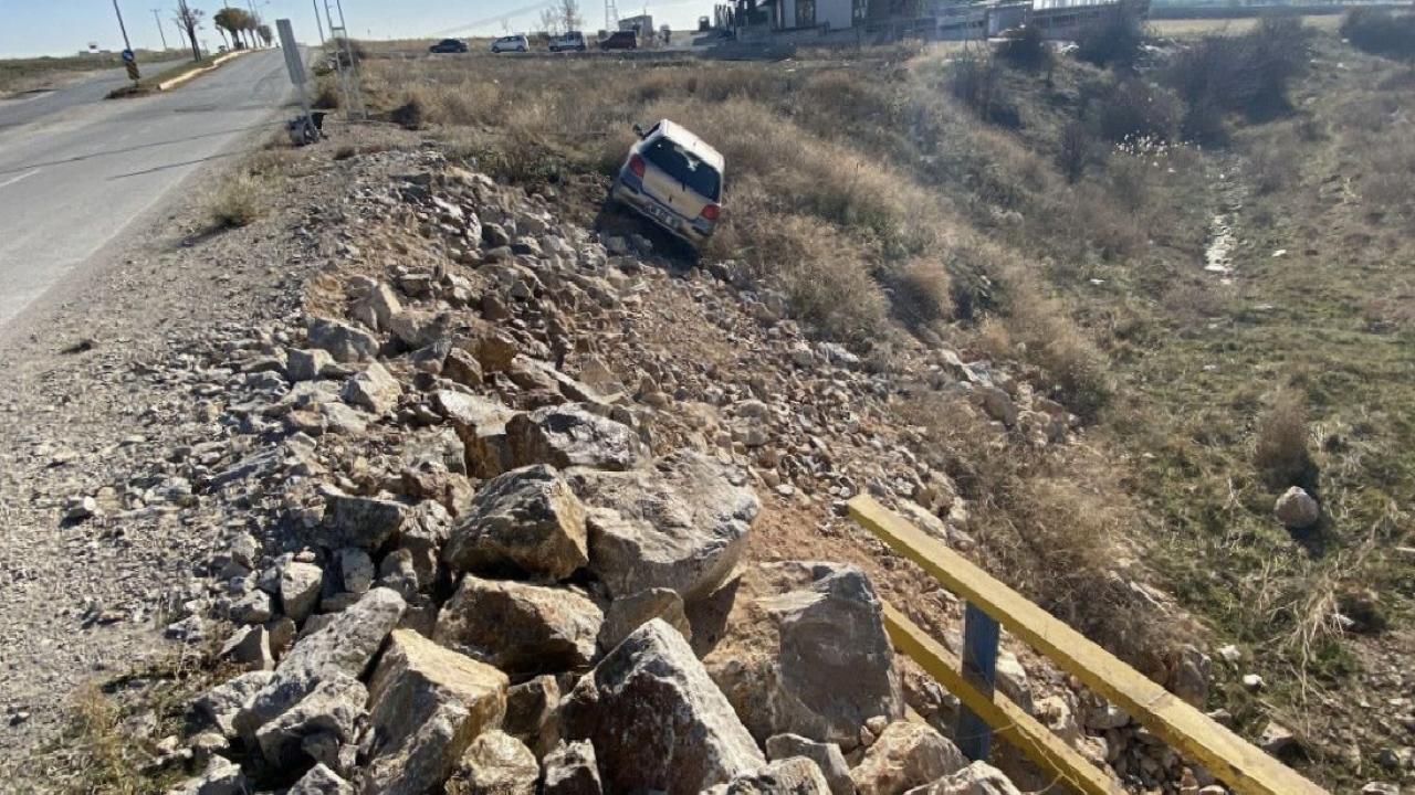 Çorum'da yoldan çıkan otomobil, taşlık alanda asılı kaldı